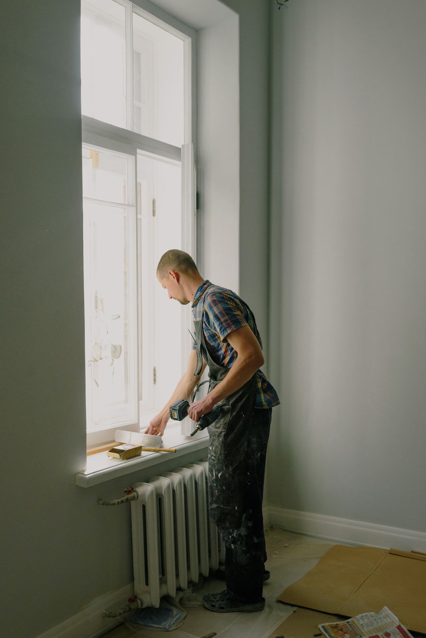Repair technician fitting a window inside a Vancouver suite
