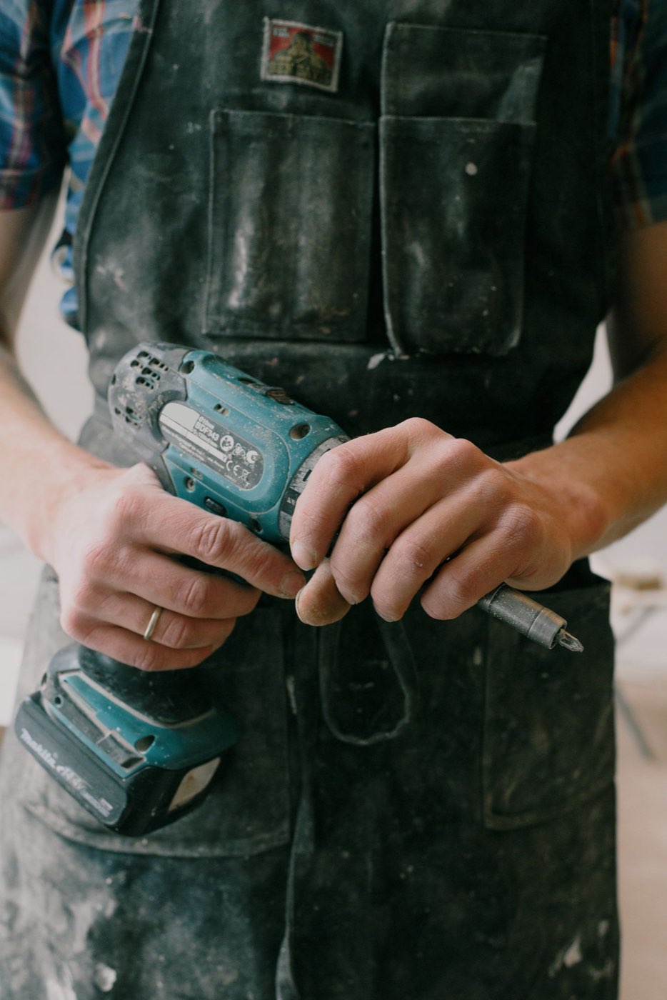 Repair technician using a drill inside an apartment